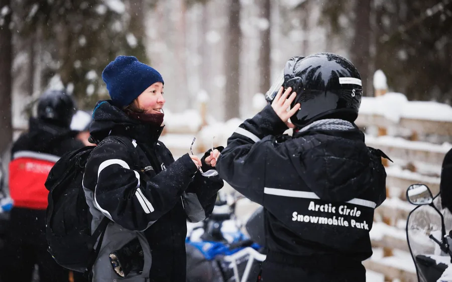 Schneemobilfahrer starten über ein verschneites Feld in Lappland